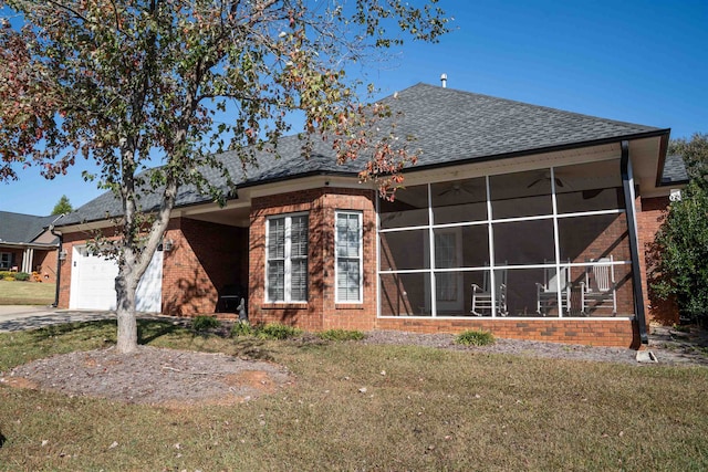 view of home's exterior with a garage, a lawn, and a sunroom