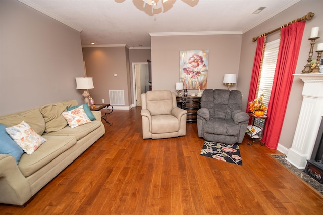 living room featuring hardwood / wood-style flooring, ceiling fan, and ornamental molding