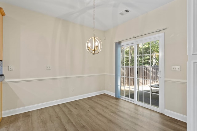 unfurnished dining area featuring hardwood / wood-style floors and a notable chandelier