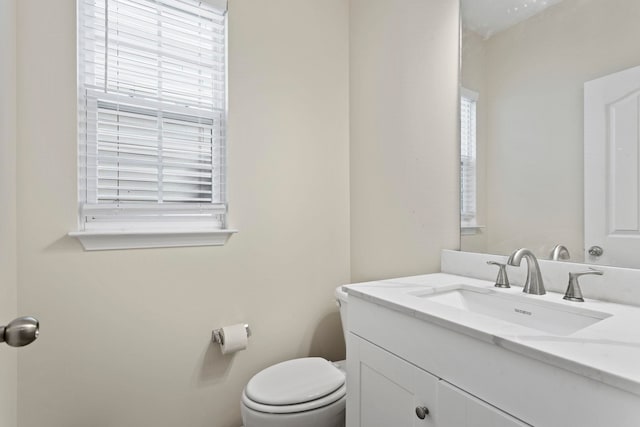 bathroom with vanity, a healthy amount of sunlight, and toilet