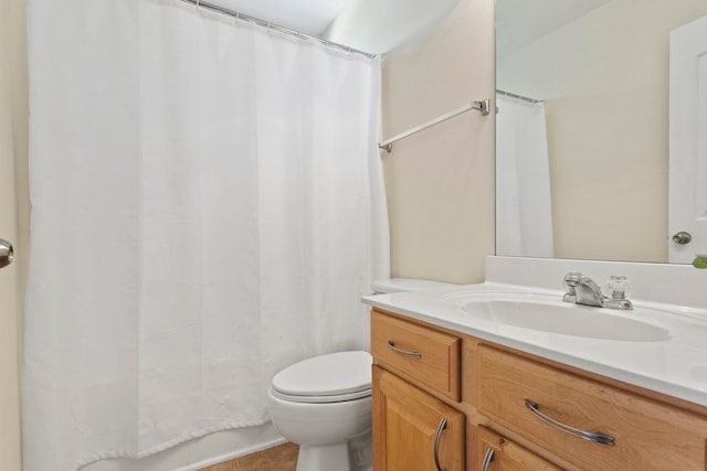 bathroom with toilet, vanity, and tile patterned flooring