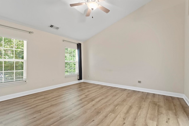 spare room featuring ceiling fan, a wealth of natural light, vaulted ceiling, and light hardwood / wood-style floors