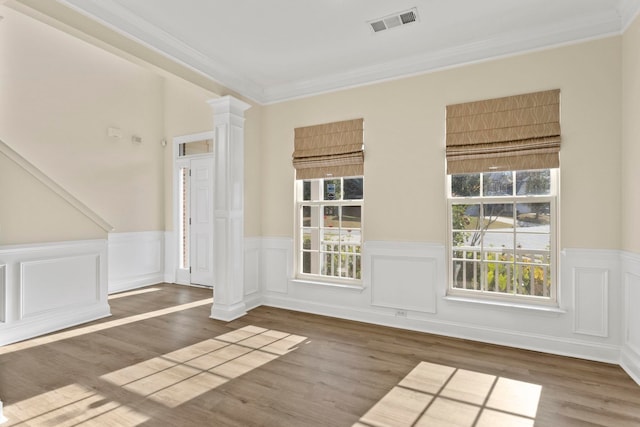 spare room with dark hardwood / wood-style flooring, ornate columns, and crown molding