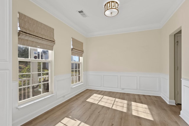 empty room with ornamental molding and light hardwood / wood-style flooring