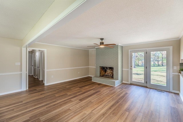 unfurnished living room featuring crown molding, a fireplace, a textured ceiling, hardwood / wood-style flooring, and ceiling fan