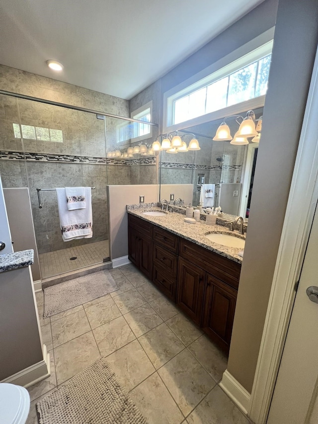 bathroom featuring a shower with shower door, vanity, and tile patterned floors