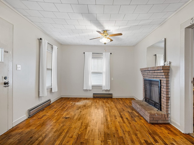 unfurnished living room featuring a baseboard heating unit, a fireplace, wood-type flooring, and ornamental molding