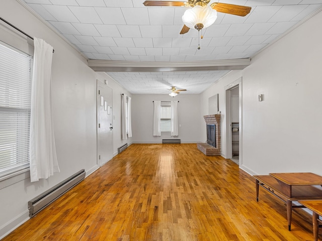 unfurnished living room with light wood-type flooring, a brick fireplace, and a baseboard heating unit