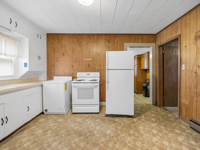 kitchen featuring white cabinets, wood walls, white appliances, and washer / dryer