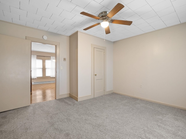 unfurnished bedroom with ceiling fan, a baseboard radiator, and light colored carpet