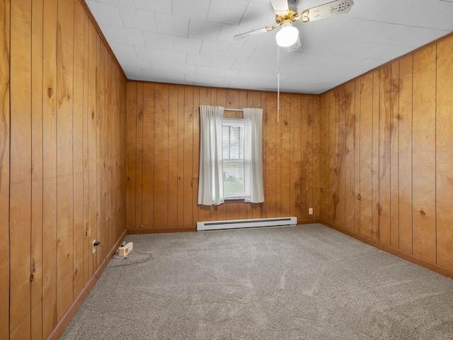 carpeted spare room featuring ceiling fan, a baseboard radiator, and wooden walls