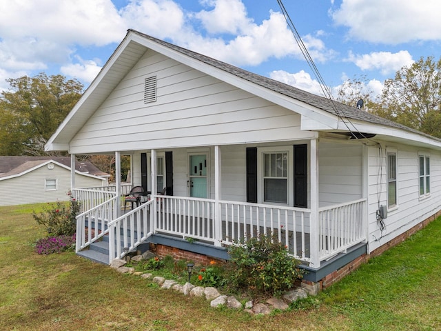 bungalow with covered porch and a front lawn