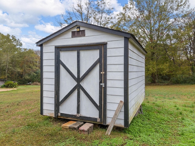 view of outbuilding with a yard