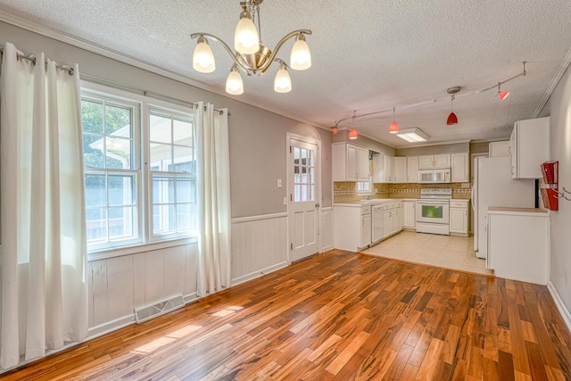 kitchen featuring white cabinets, white appliances, a textured ceiling, and light wood-type flooring