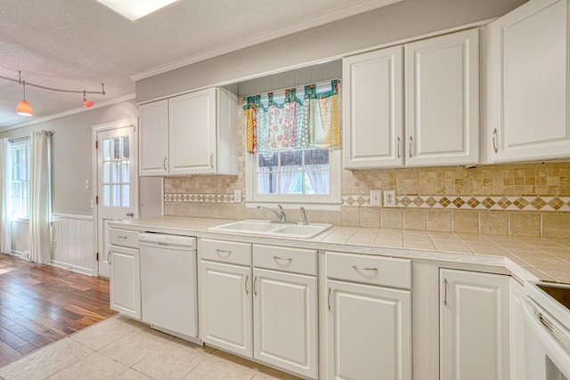 kitchen featuring light hardwood / wood-style flooring, white appliances, a textured ceiling, and white cabinets