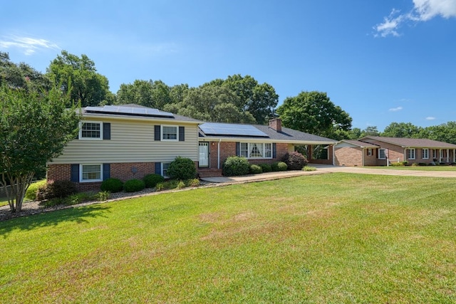 split level home with a front lawn and solar panels