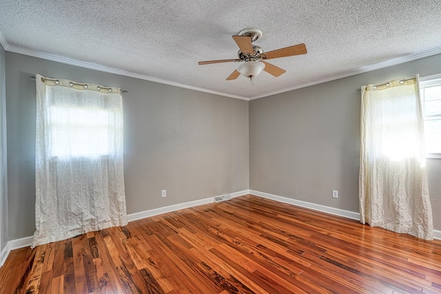 unfurnished room with ceiling fan, a wealth of natural light, wood-type flooring, and a textured ceiling