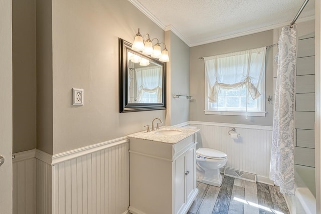 full bathroom featuring a textured ceiling, hardwood / wood-style flooring, vanity, crown molding, and shower / bath combination with curtain