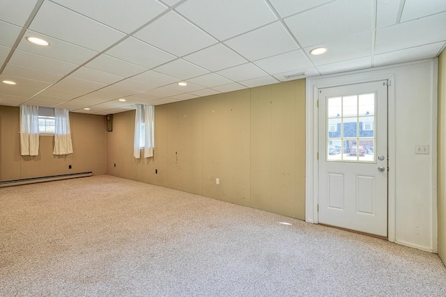 basement featuring baseboard heating, carpet floors, and a drop ceiling