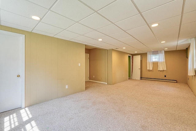 basement featuring carpet, a baseboard radiator, and a paneled ceiling