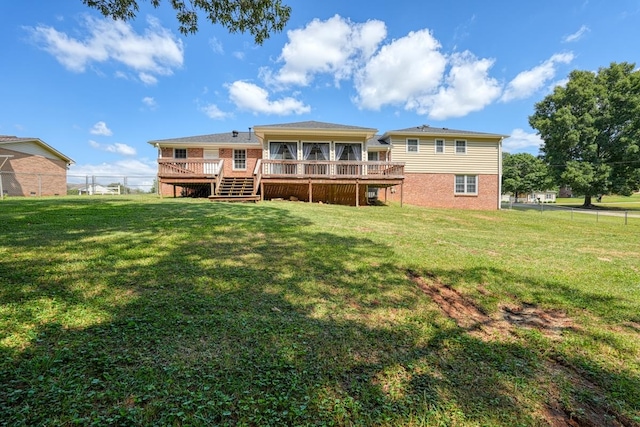 rear view of house with a yard and a wooden deck