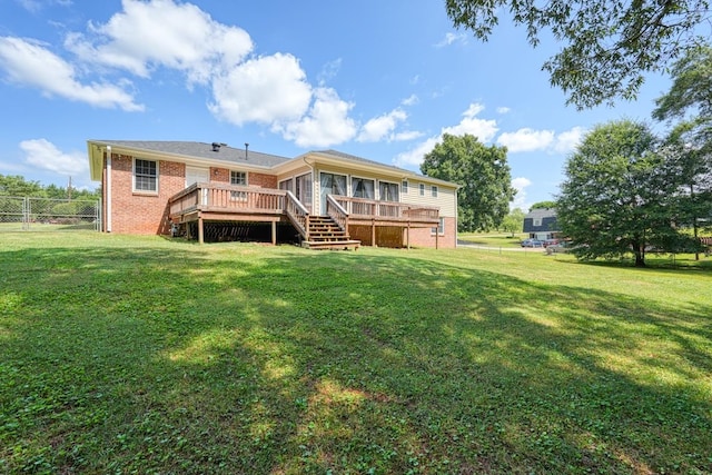 back of house featuring a lawn and a deck