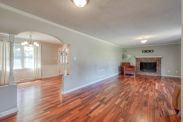 unfurnished living room with hardwood / wood-style floors, ornamental molding, and a textured ceiling