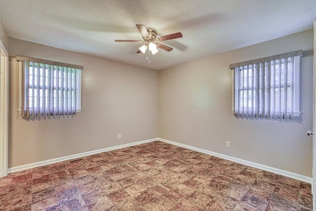 empty room with a textured ceiling and ceiling fan