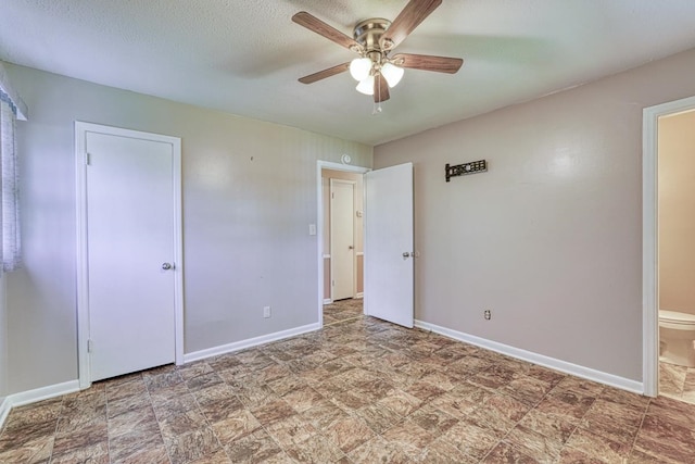 unfurnished bedroom featuring ceiling fan, ensuite bath, and a textured ceiling