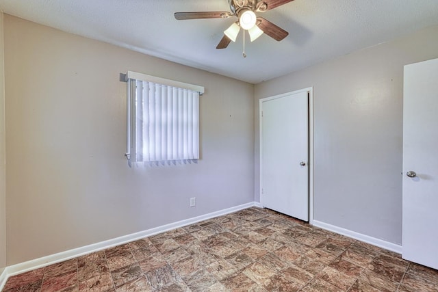 unfurnished room with ceiling fan and a textured ceiling