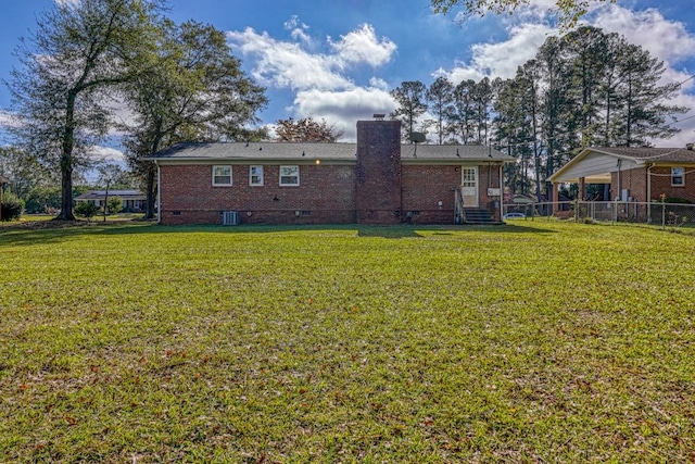 rear view of house with central air condition unit and a lawn