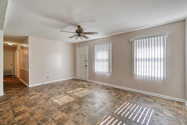 foyer entrance with ceiling fan and a textured ceiling