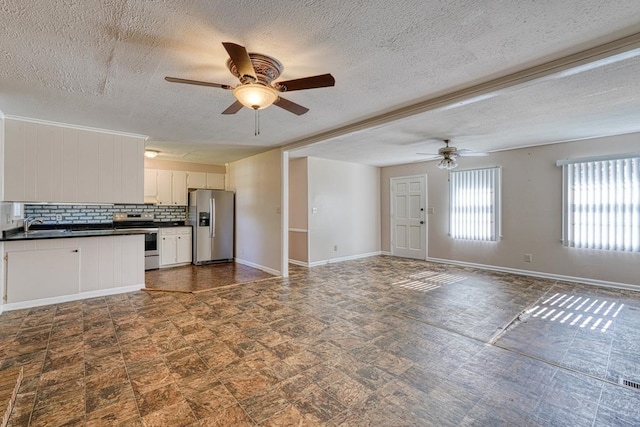 kitchen with white cabinetry, appliances with stainless steel finishes, a textured ceiling, backsplash, and ceiling fan