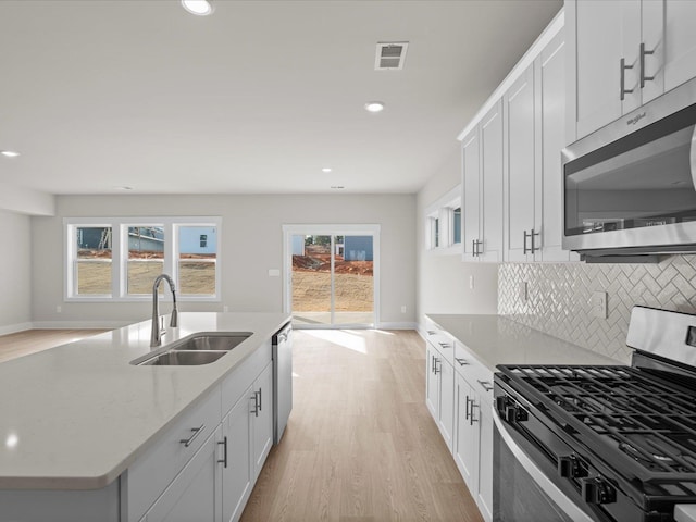 kitchen featuring white cabinetry, appliances with stainless steel finishes, sink, and light hardwood / wood-style floors