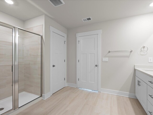 bathroom with vanity and a shower with shower door