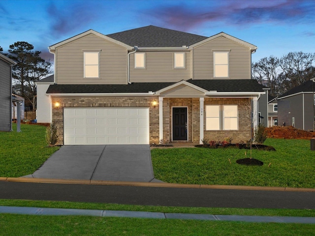 view of front of home with a garage and a lawn