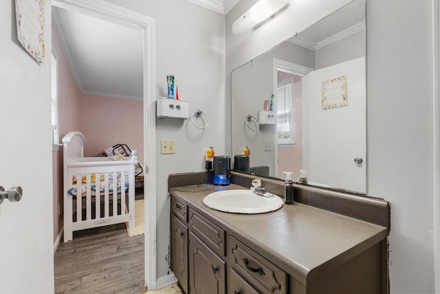 bathroom featuring hardwood / wood-style floors, vanity, and ornamental molding