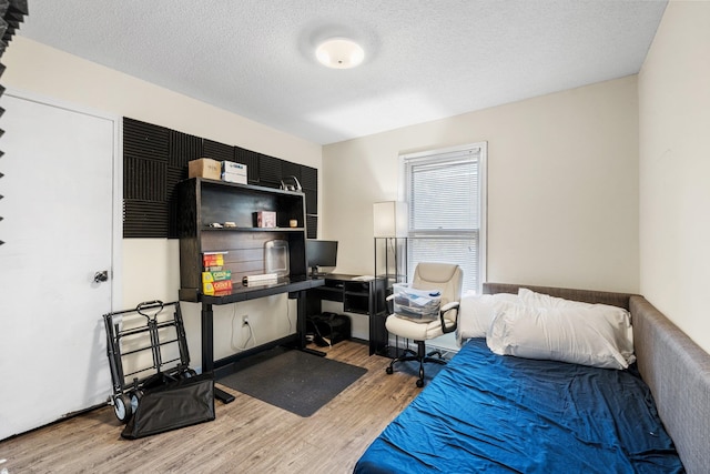 bedroom featuring a textured ceiling and hardwood / wood-style flooring