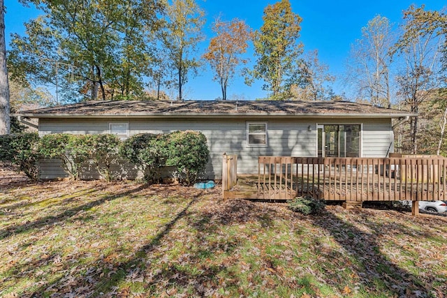 rear view of property with a wooden deck and a yard