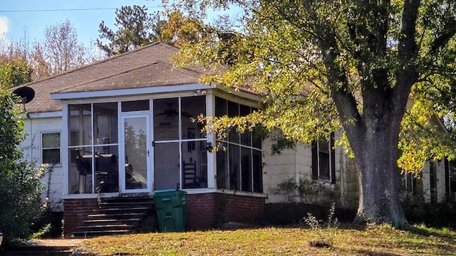 view of property exterior with a sunroom