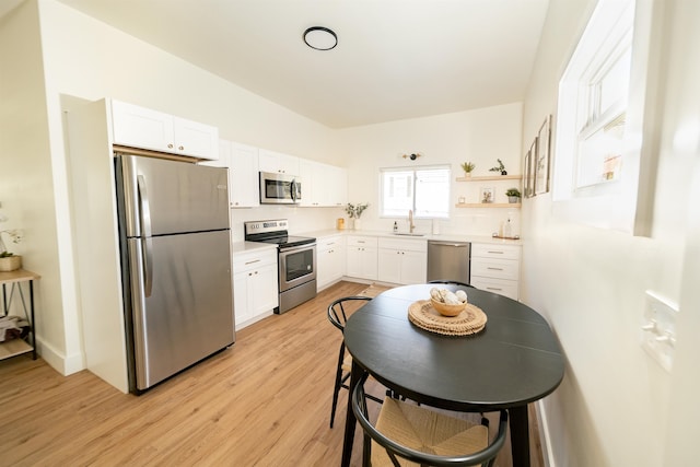 kitchen featuring light hardwood / wood-style flooring, white cabinets, sink, and stainless steel appliances