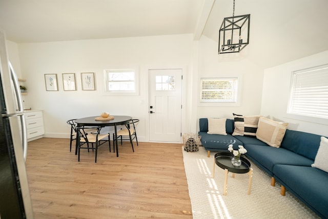 living room featuring beamed ceiling, a healthy amount of sunlight, and light hardwood / wood-style flooring