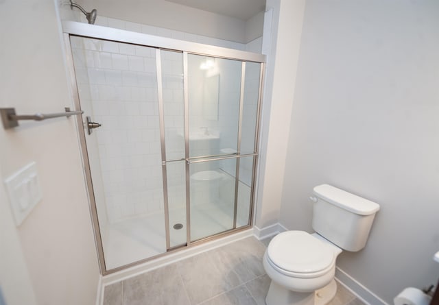 bathroom featuring toilet and a shower with door