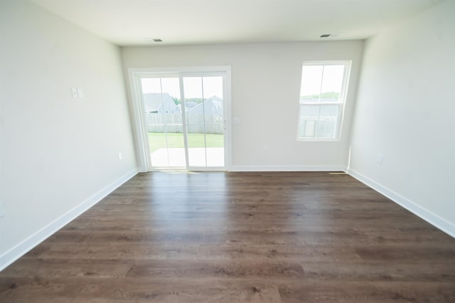 unfurnished room with a healthy amount of sunlight and dark hardwood / wood-style floors