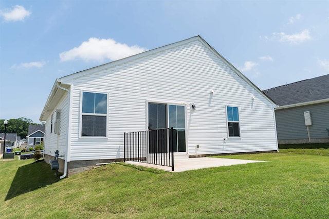 rear view of property featuring a patio and a yard