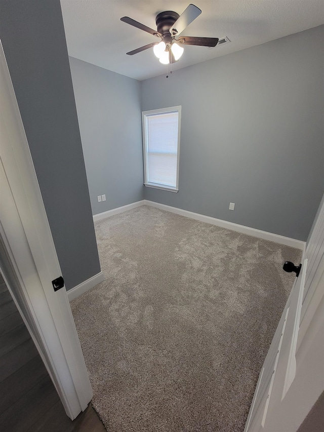 carpeted spare room with ceiling fan