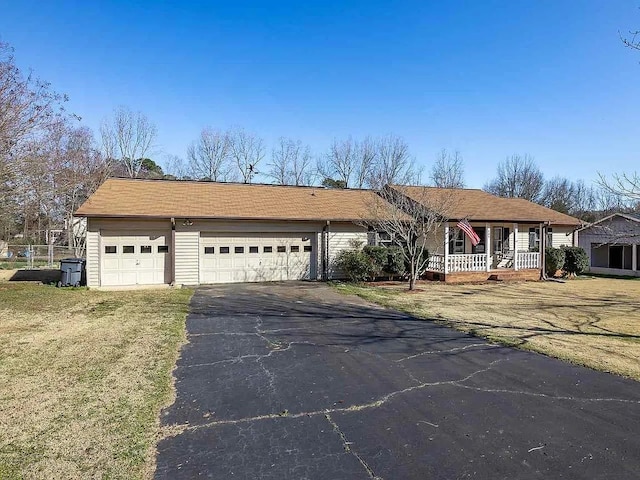 single story home featuring a garage, a front lawn, and a porch