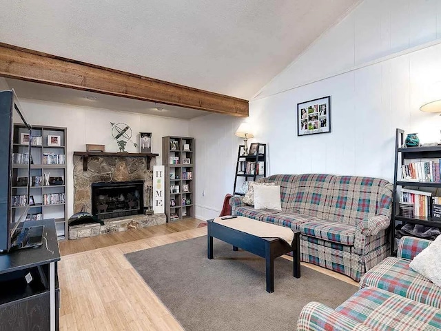 living room featuring a fireplace, wood-type flooring, and lofted ceiling with beams