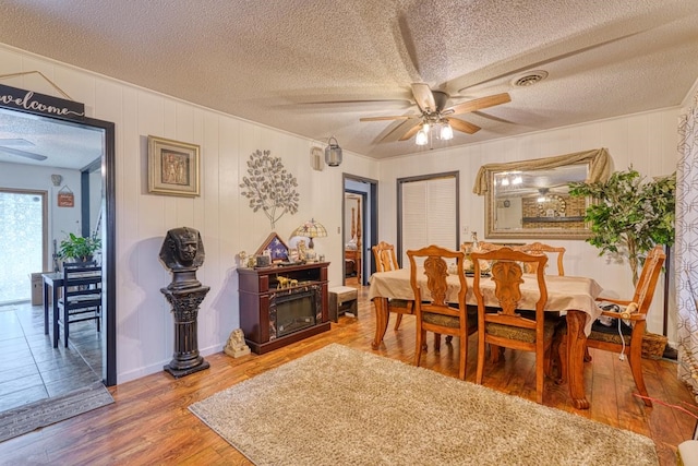 dining space featuring ceiling fan, hardwood / wood-style flooring, and a textured ceiling