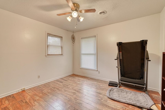 interior space with a textured ceiling, light hardwood / wood-style flooring, and ceiling fan